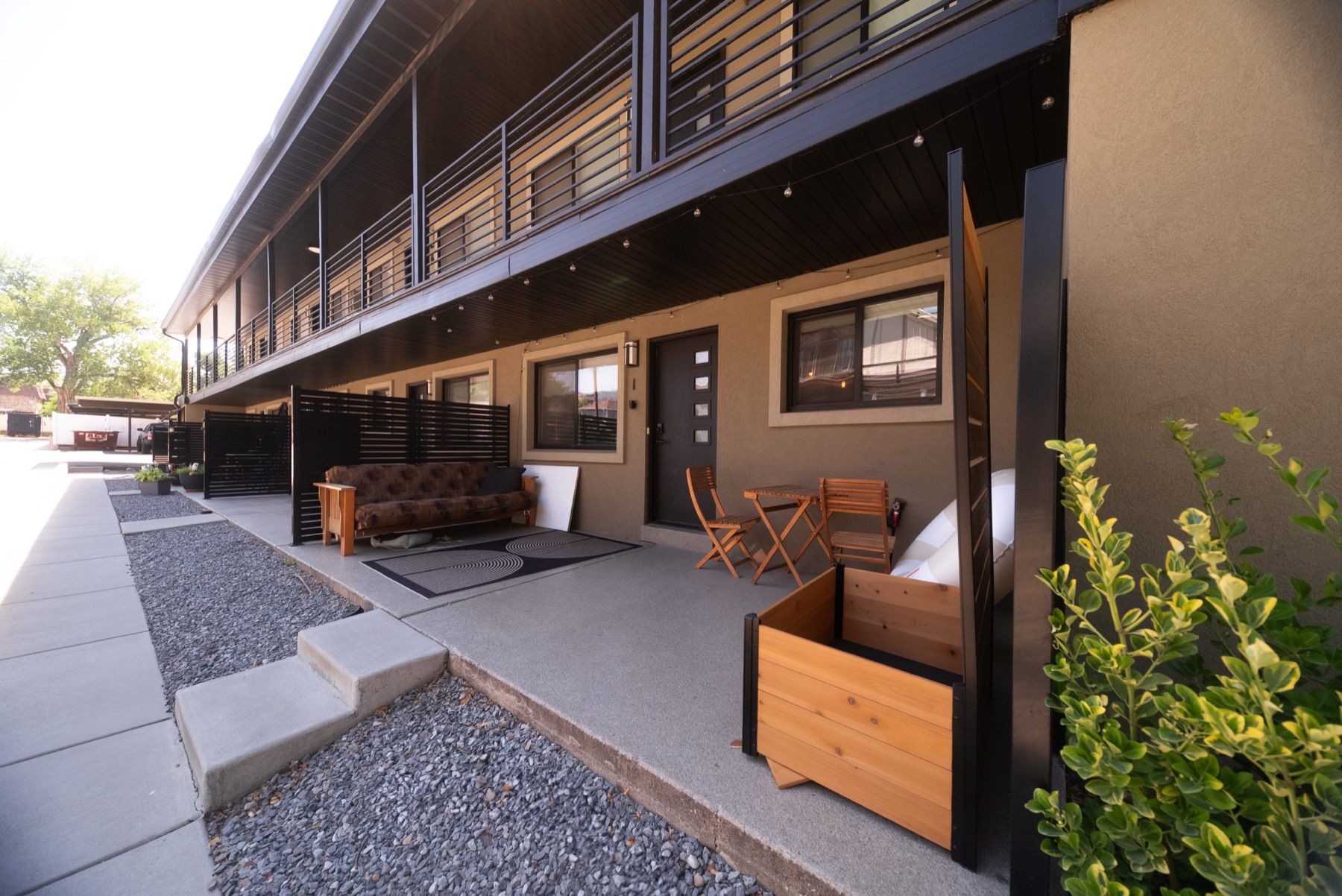 Walkway between residences with patios, seating, and planters