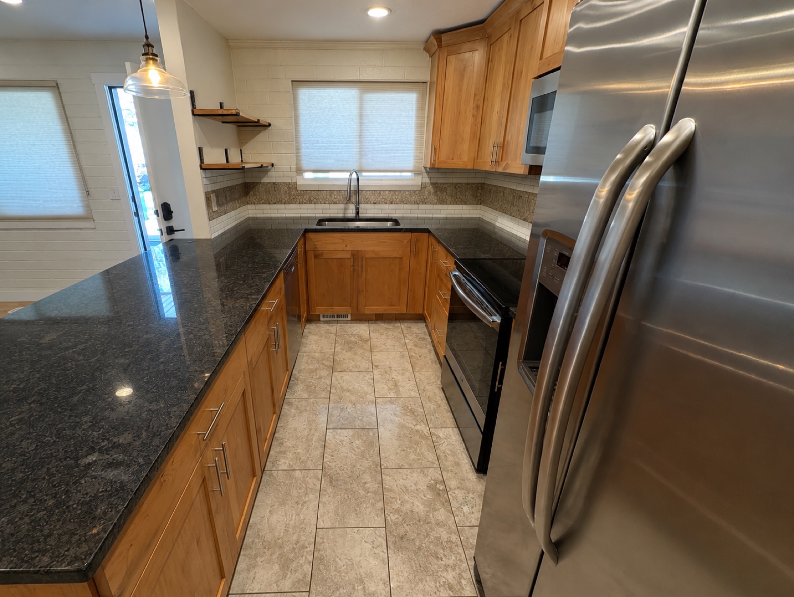 Kitchen with granite counters, stainless appliances, and wood cabinetry