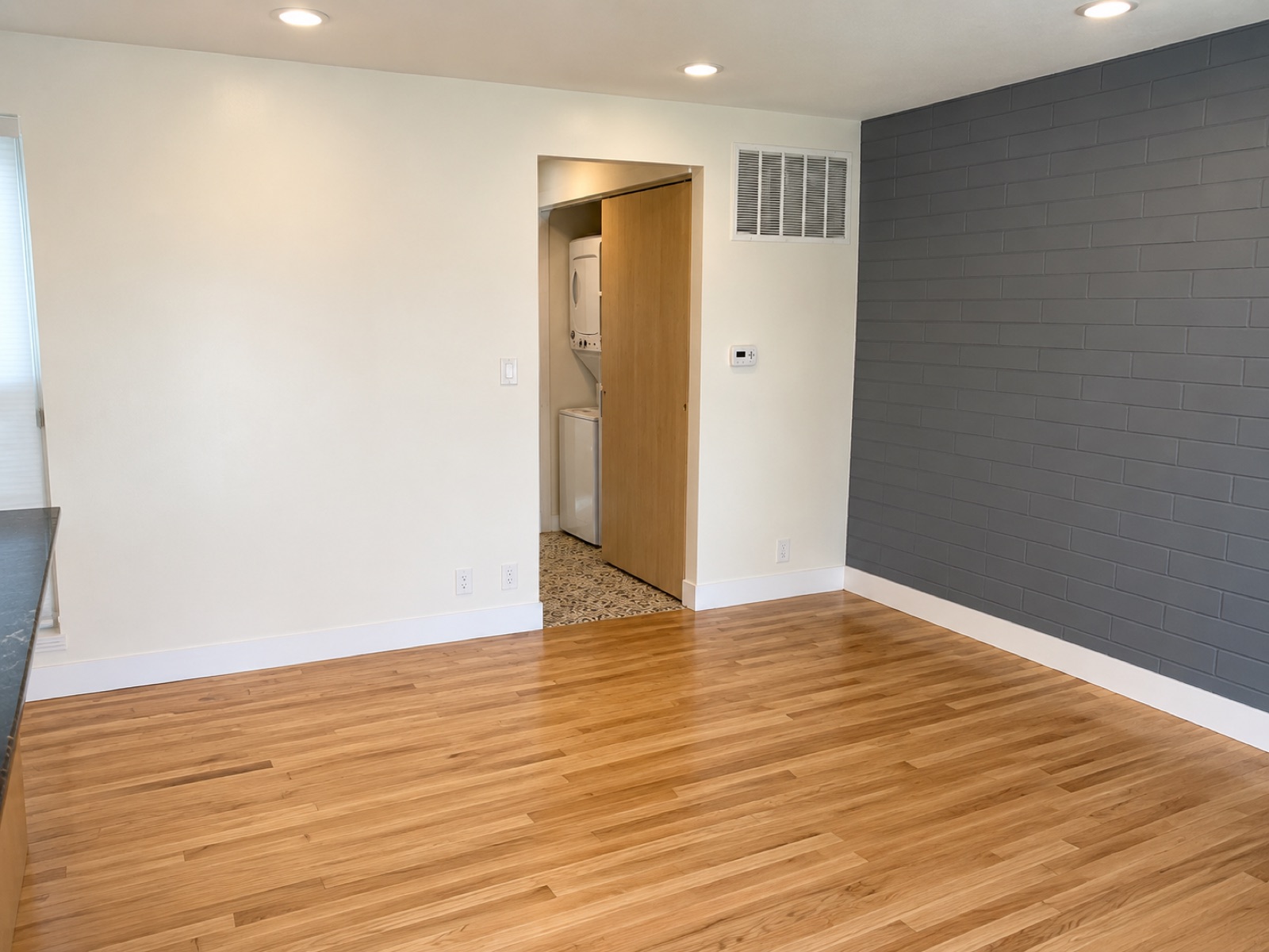 Living area with in-unit stacked washer and dryer and painted accent wall