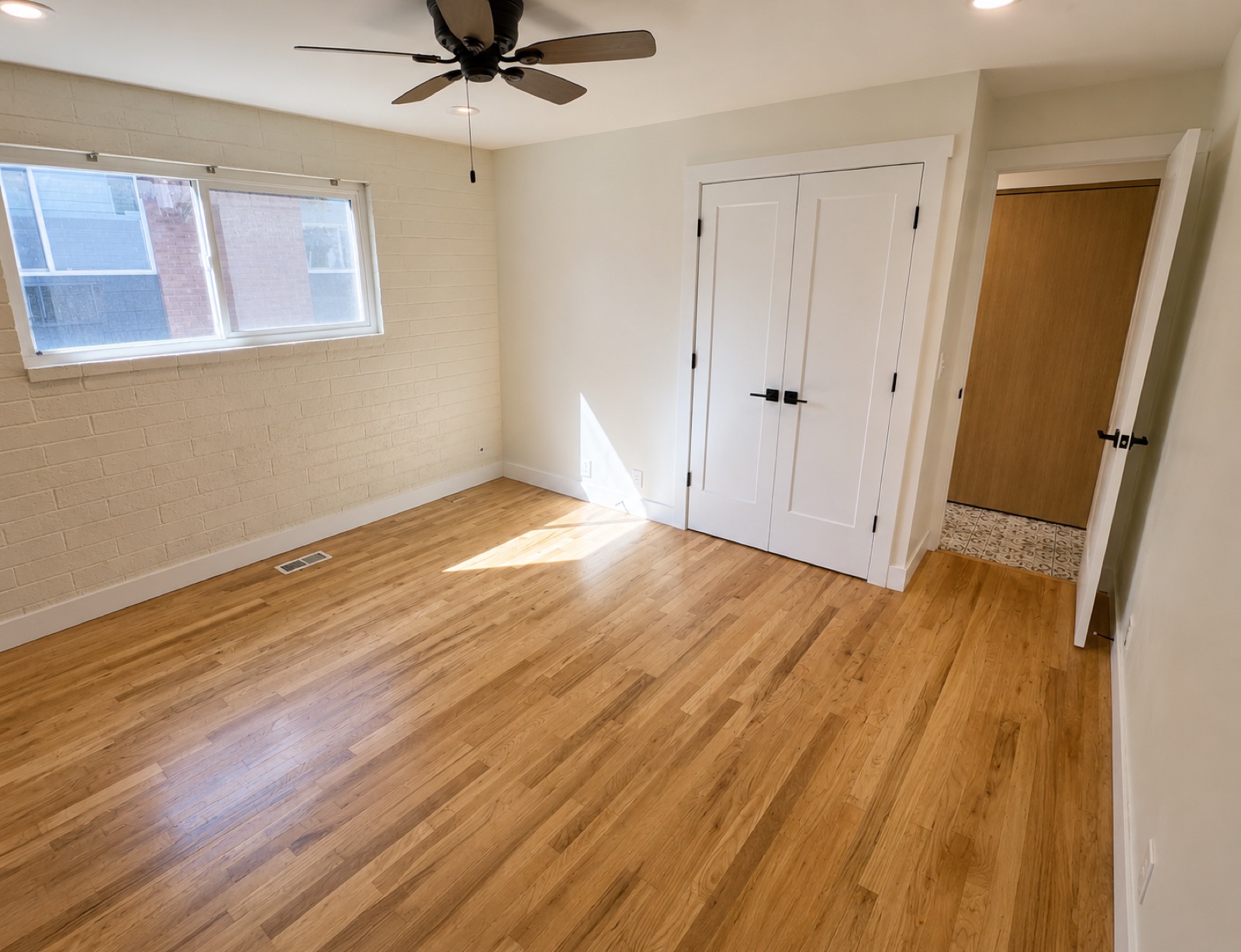 Bedroom with hardwood floors, ceiling fan, and closet