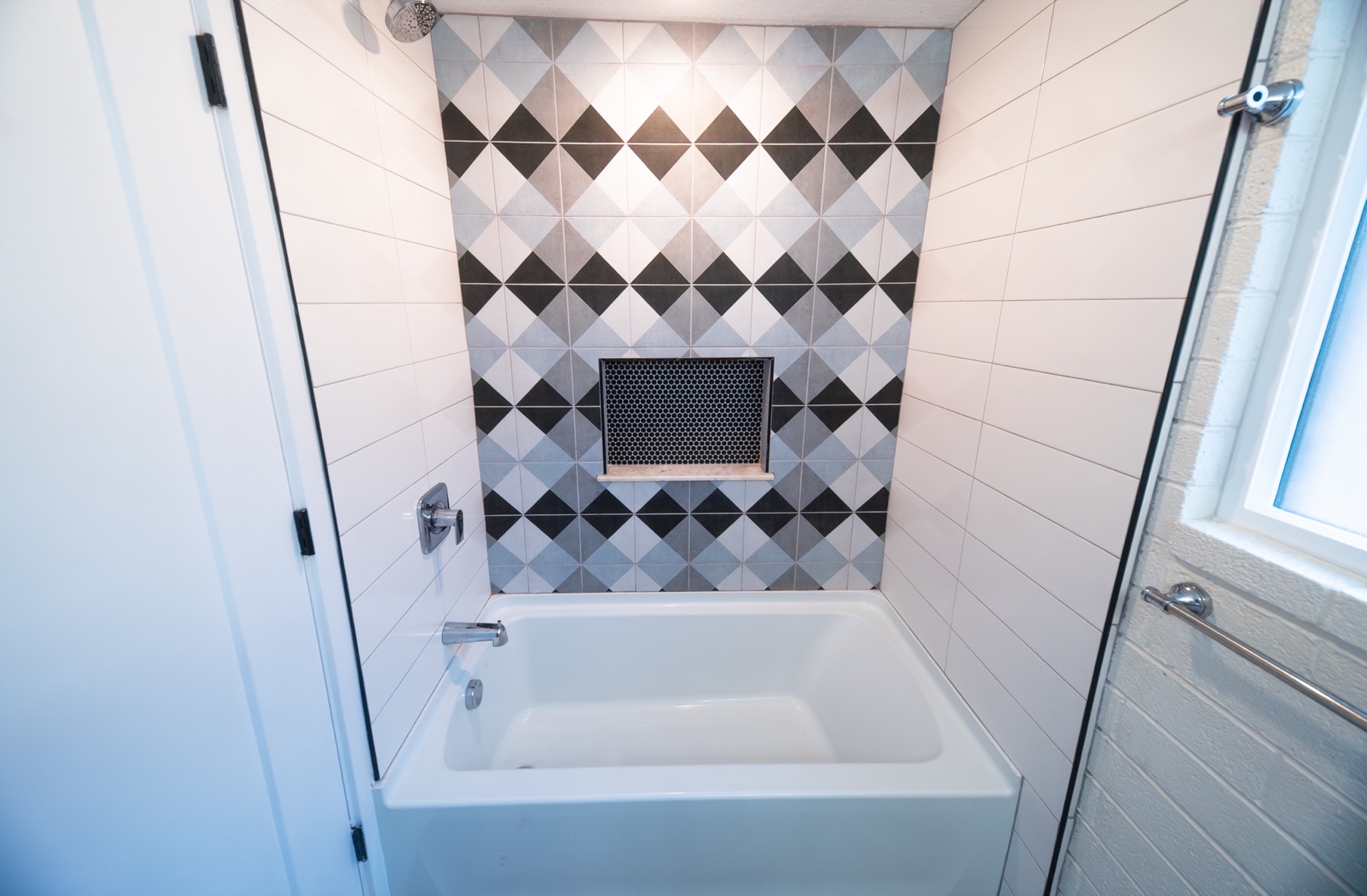 Bathroom with a soaking tub and diamond-pattern accent tile