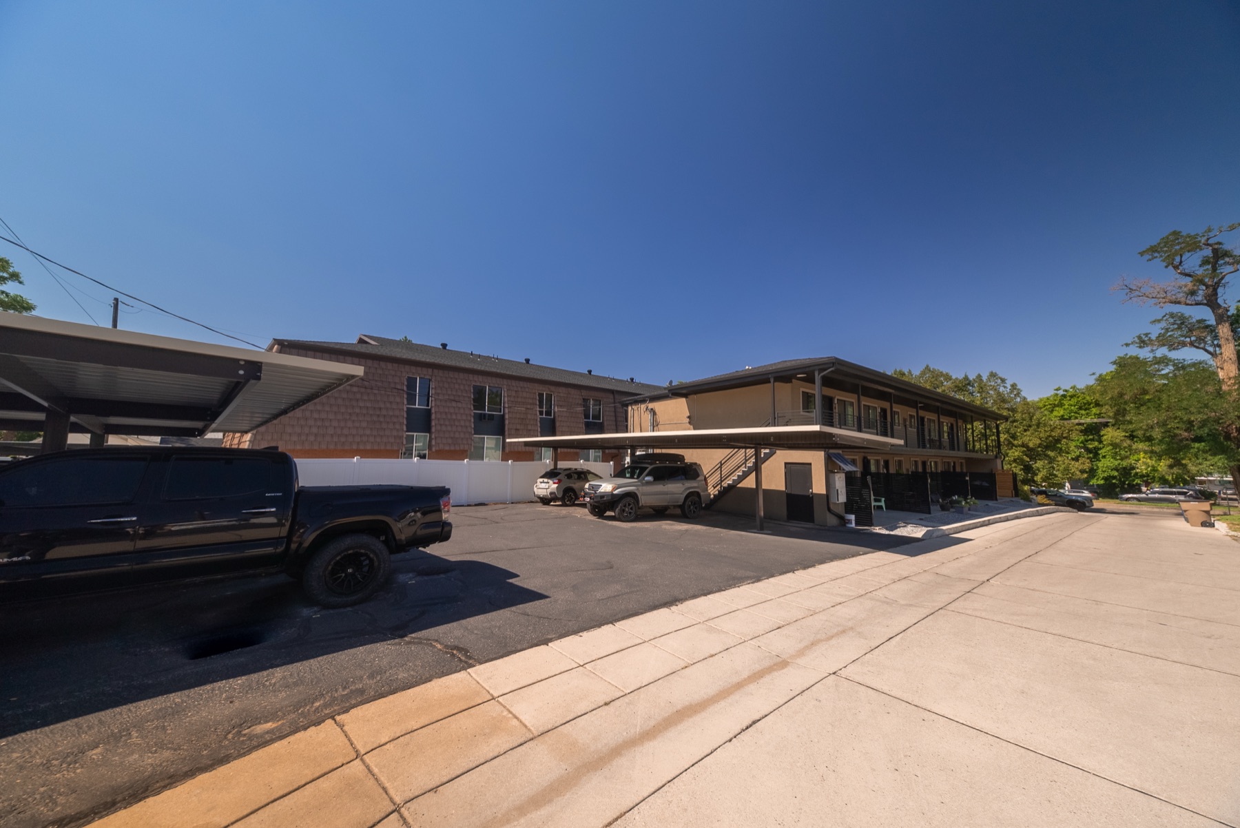 Side view of the building with covered parking and off-street parking spaces