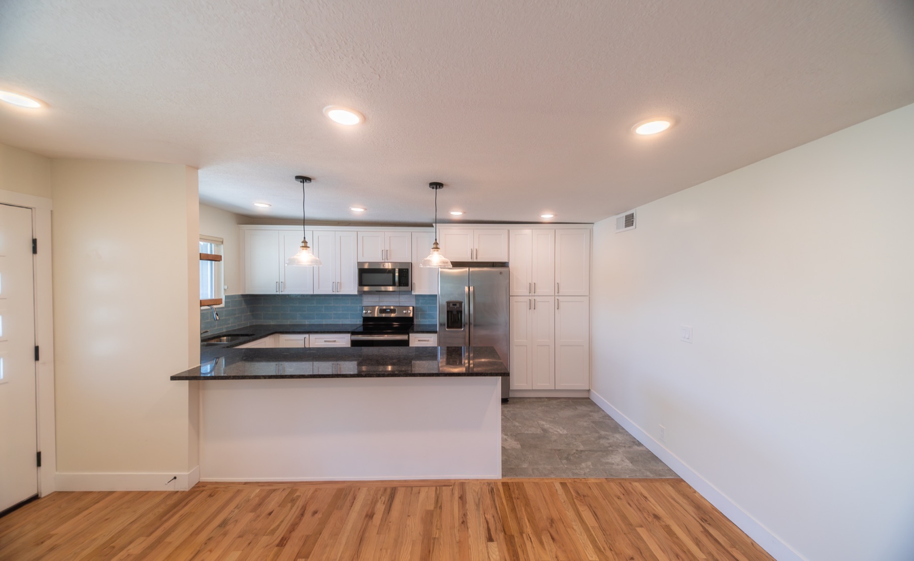 Kitchen and island seen from the living area with pendant lighting